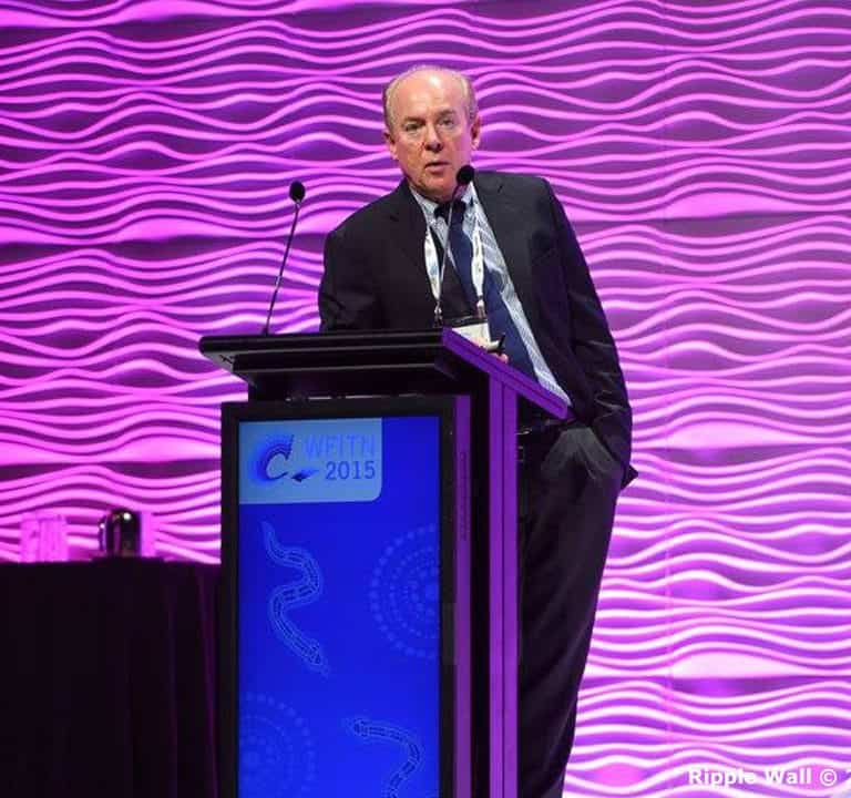 A man stands at a podium labeled 