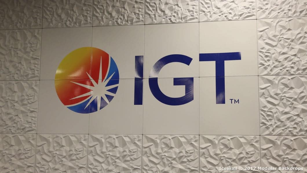 The image shows a wall featuring a logo that includes a stylized sunburst design in a yellow, orange, and red gradient next to the letters 