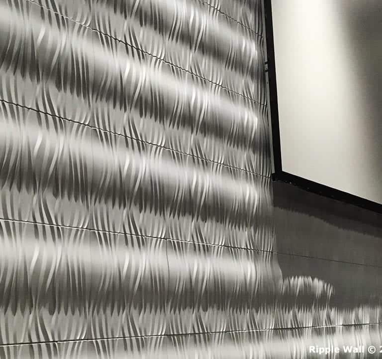 A textured ripple wall with a large blank screen hanging above showcases the elegance of Ripple Wall Modular Backdrops. A watermark at the lower right corner reads 