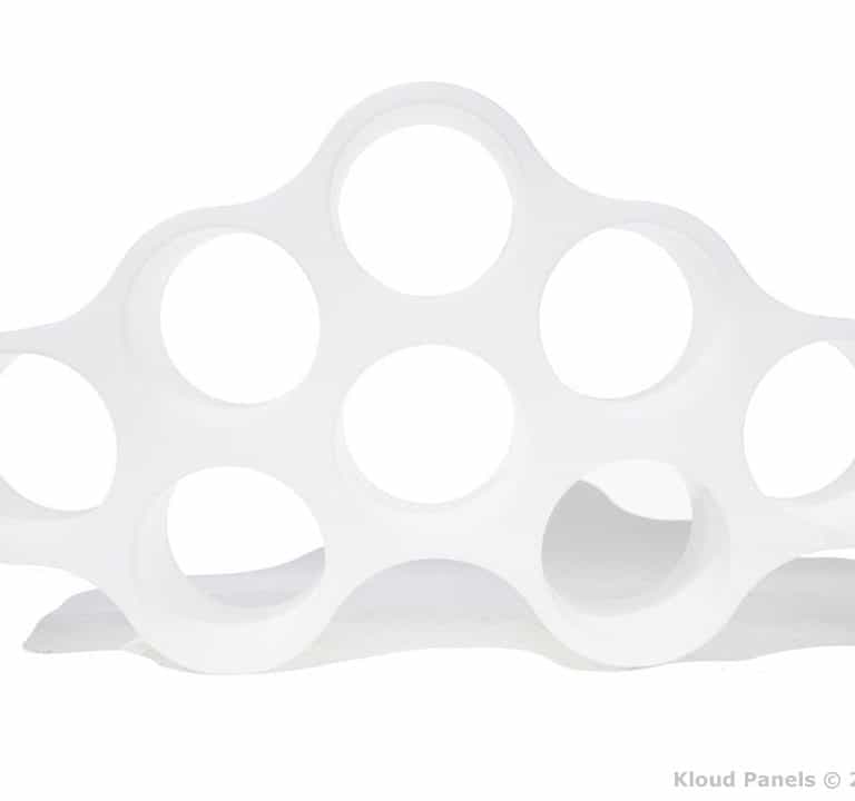 A white, cloud-shaped object with multiple circular cutouts arranged in a symmetrical pattern. Text at bottom right reads 